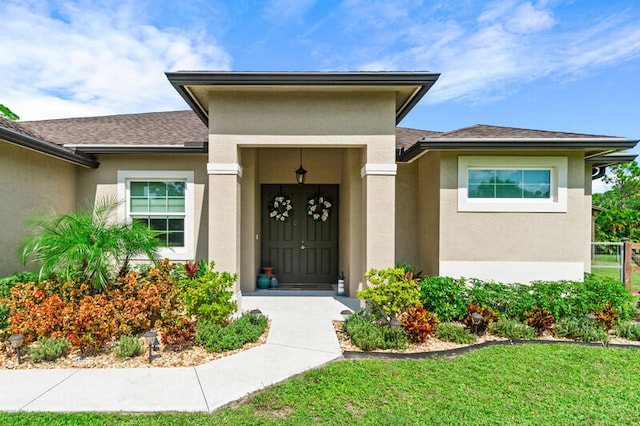 property entrance featuring a lawn