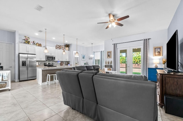 living room with french doors, light tile patterned floors, and ceiling fan