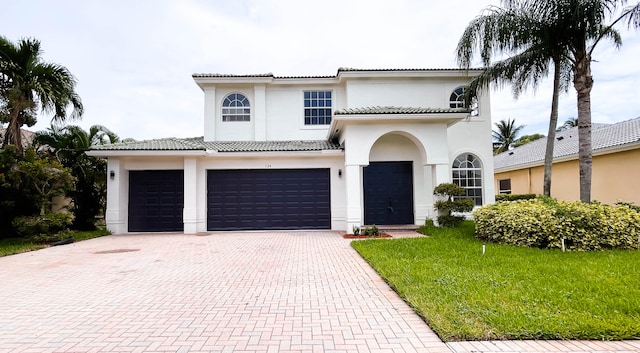 mediterranean / spanish-style home with a garage and a front lawn