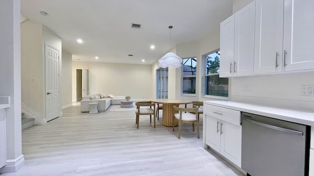 kitchen featuring white cabinetry, light hardwood / wood-style floors, decorative light fixtures, and stainless steel dishwasher