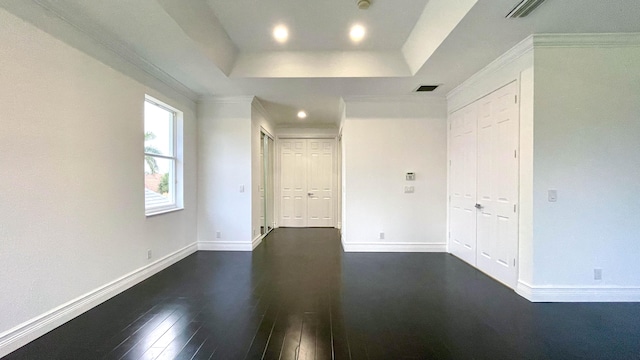 unfurnished bedroom with ornamental molding, dark hardwood / wood-style floors, and a raised ceiling