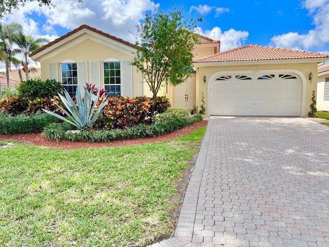 mediterranean / spanish-style house featuring a garage and a front yard