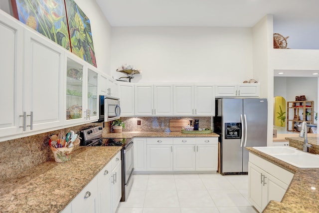 kitchen with sink, white cabinetry, light stone counters, tasteful backsplash, and stainless steel appliances