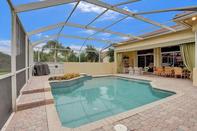 view of swimming pool with a patio, area for grilling, and a lanai