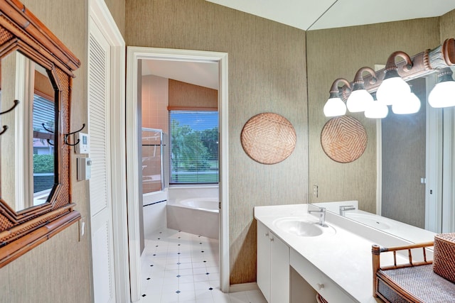 bathroom with vanity, a bathing tub, and vaulted ceiling