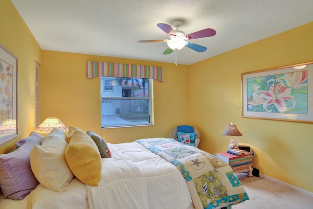 bedroom with light tile patterned flooring, a textured ceiling, and ceiling fan