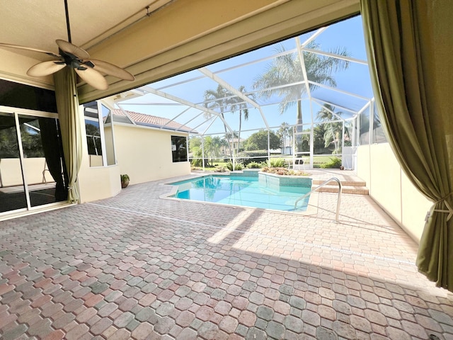 view of pool with glass enclosure and a patio area