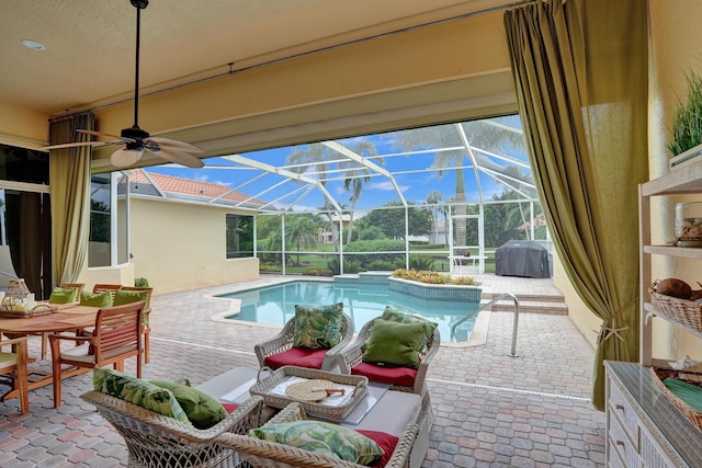 view of pool with grilling area, a lanai, ceiling fan, and a patio area