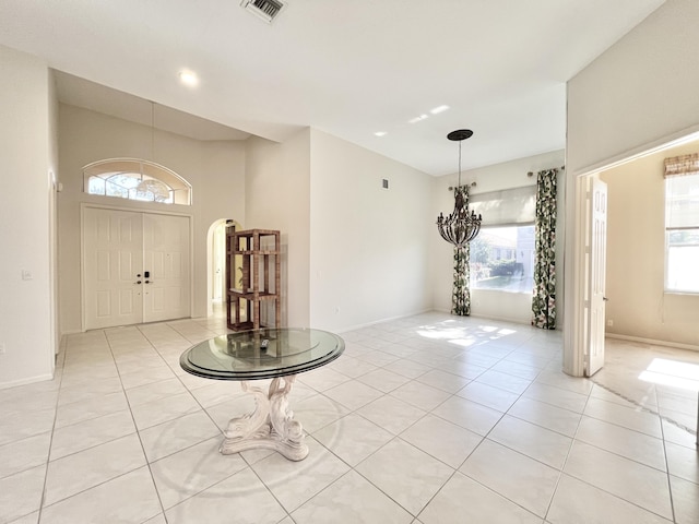 tiled foyer featuring plenty of natural light and a notable chandelier