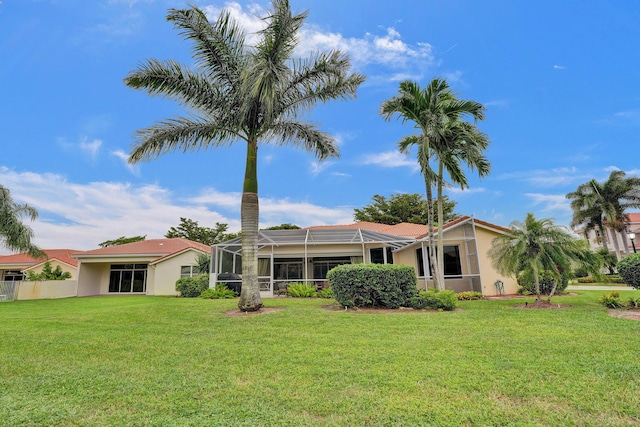 back of house with a yard and a lanai