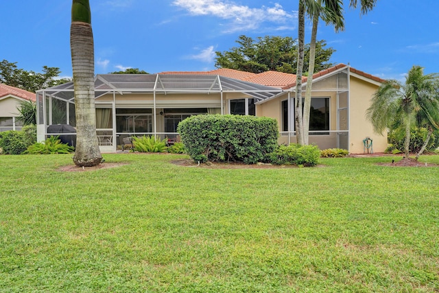 back of property with a yard and a lanai