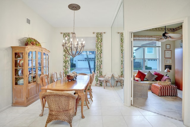 tiled dining area featuring ceiling fan with notable chandelier