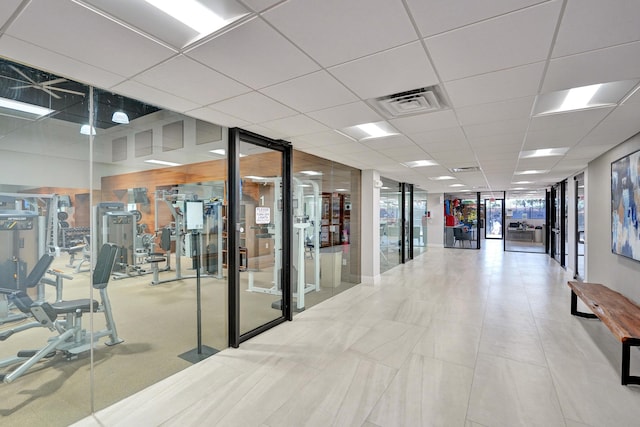 interior space featuring a paneled ceiling and floor to ceiling windows