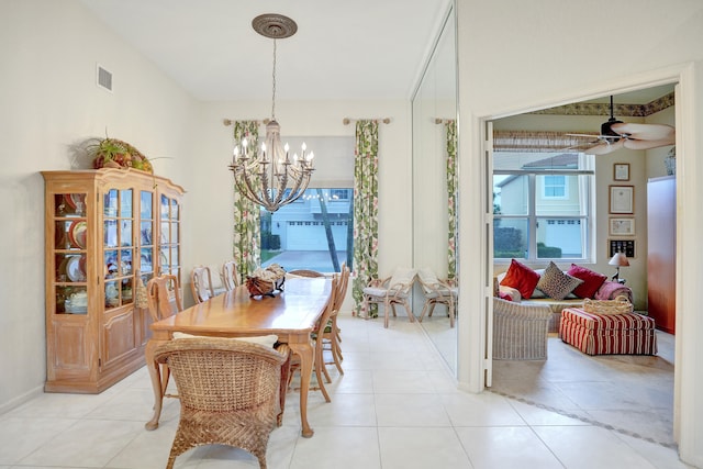 dining area featuring ceiling fan with notable chandelier and light tile patterned flooring