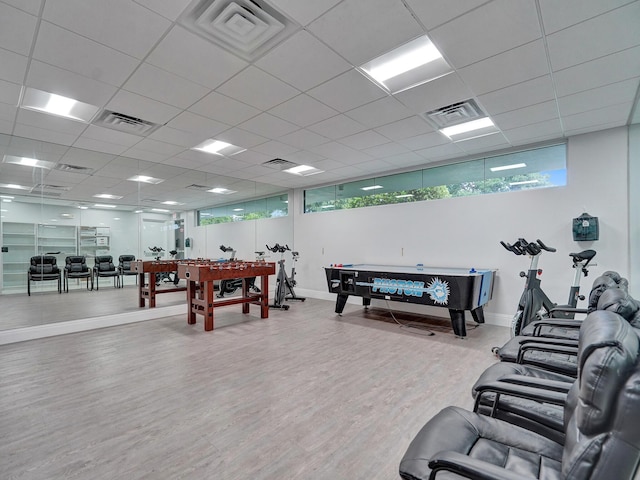 interior space with a drop ceiling and wood-type flooring