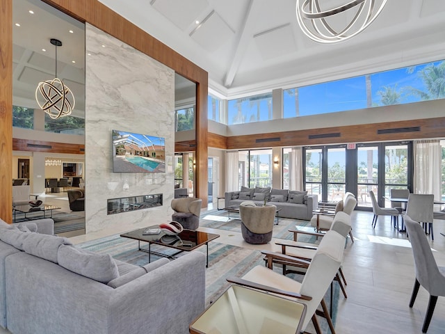 living room featuring a high ceiling, a premium fireplace, and a healthy amount of sunlight