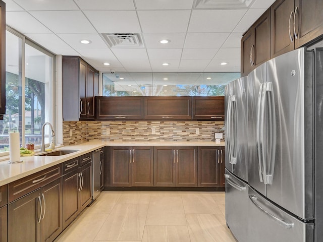 kitchen with sink, decorative backsplash, dark brown cabinets, and appliances with stainless steel finishes