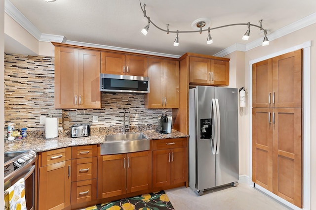 kitchen with appliances with stainless steel finishes, sink, backsplash, dark stone counters, and crown molding