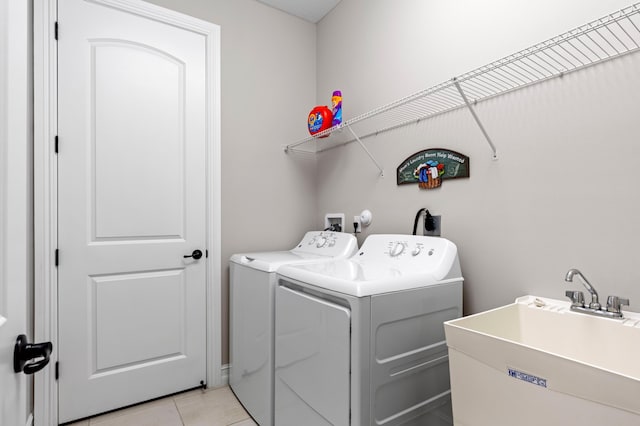 laundry area featuring sink, washing machine and dryer, and light tile patterned floors