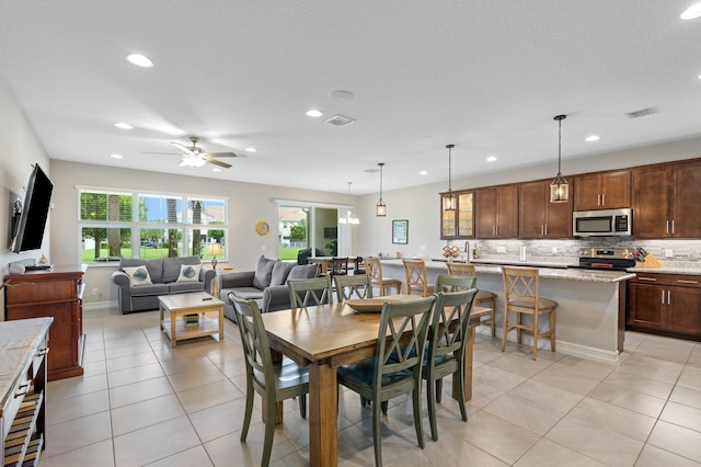 tiled dining room featuring ceiling fan and a textured ceiling