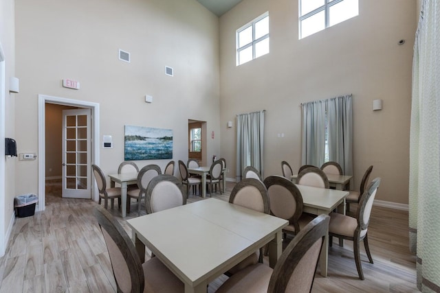 dining space featuring a high ceiling and light wood-type flooring