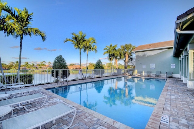 view of swimming pool with a water view and a patio