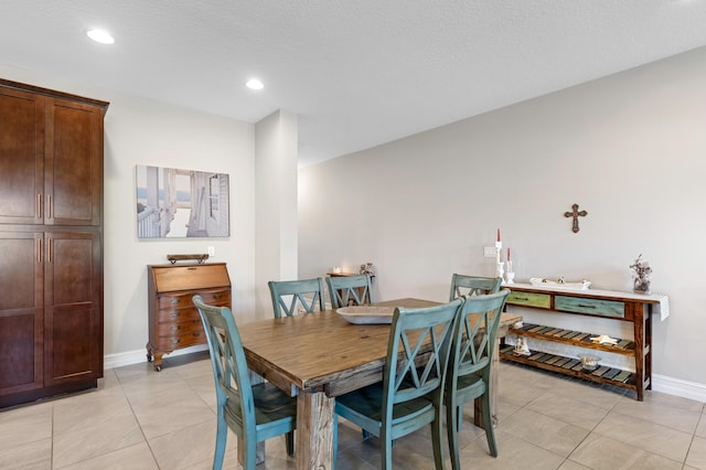 tiled dining space featuring a textured ceiling