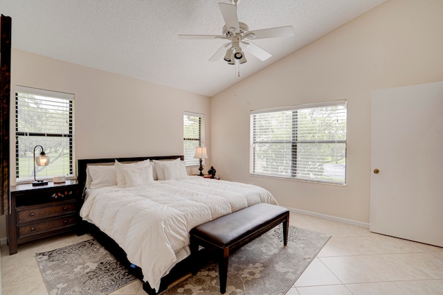 bedroom with ceiling fan, light tile patterned floors, multiple windows, and vaulted ceiling