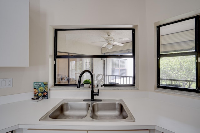 kitchen featuring white cabinets, ceiling fan, and sink