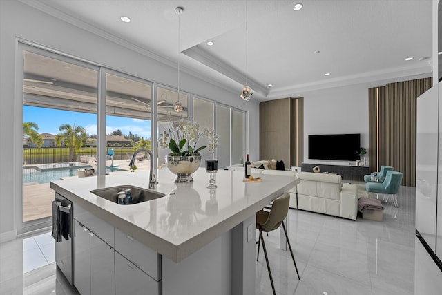 kitchen featuring a center island with sink, light stone countertops, stainless steel dishwasher, pendant lighting, and sink