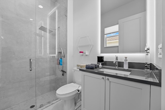 bathroom featuring vanity, toilet, and a shower with shower door