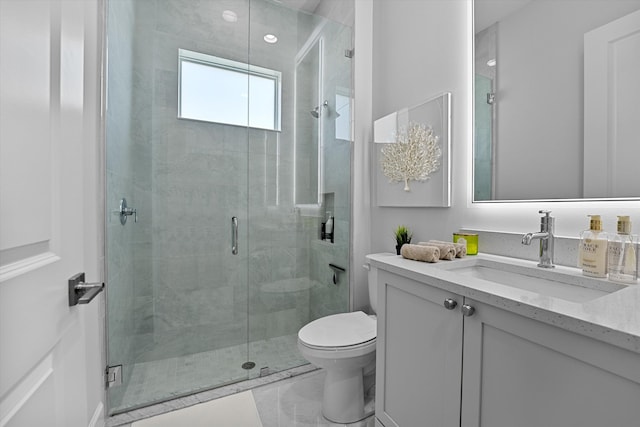 bathroom with vanity, a shower with shower door, and toilet