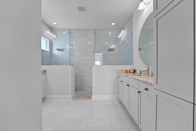 bathroom with vanity and a tile shower