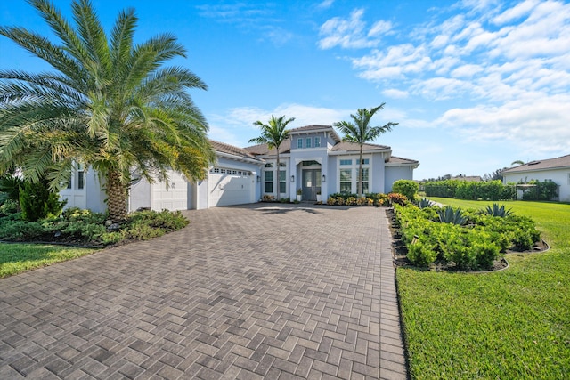 mediterranean / spanish house with a front yard and a garage