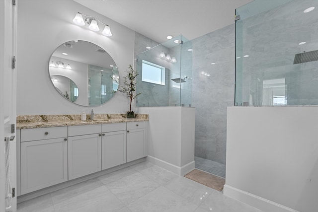 bathroom with a tile shower and vanity