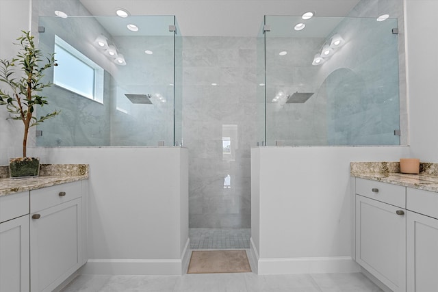 bathroom featuring a tile shower, vanity, and tile patterned floors