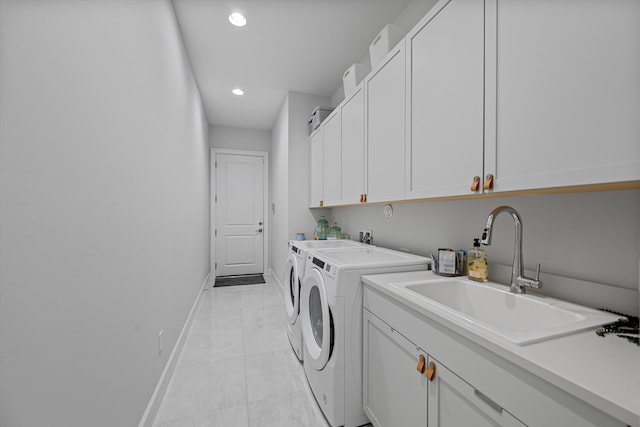 washroom featuring sink, washing machine and clothes dryer, light tile patterned floors, and cabinets