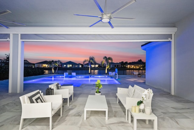 pool at dusk featuring a patio, ceiling fan, and pool water feature