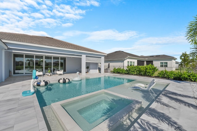 view of swimming pool featuring a patio area and an in ground hot tub