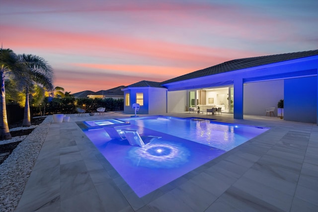 pool at dusk featuring a patio