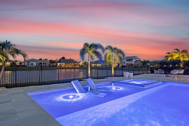 pool at dusk with a patio area