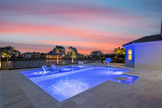 pool at dusk with a patio area