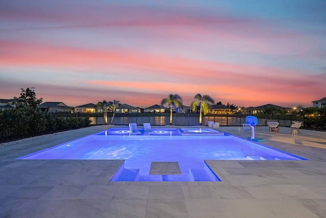 pool at dusk with a patio area