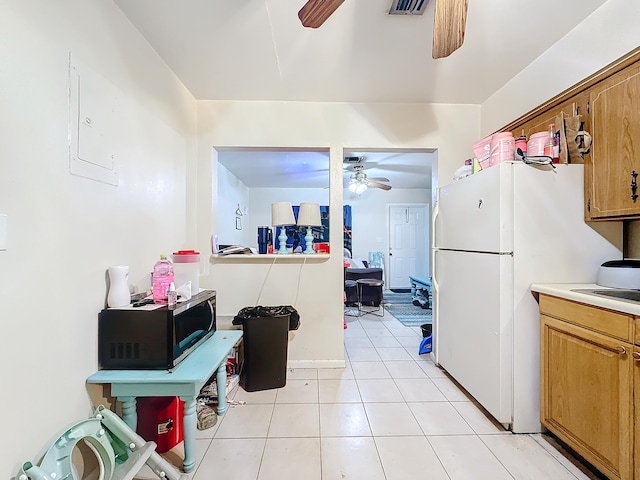 kitchen with electric panel, ceiling fan, light tile patterned floors, and white refrigerator