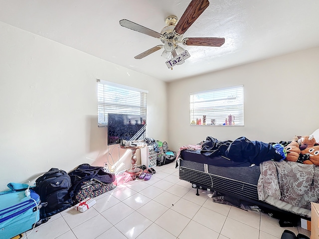 tiled bedroom with multiple windows and ceiling fan