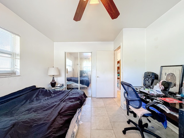 bedroom with a closet, light tile patterned flooring, and ceiling fan