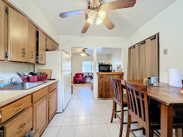 kitchen featuring sink, light tile patterned flooring, and white fridge