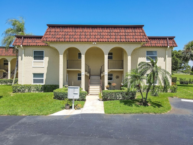 view of front of home featuring a front lawn and a balcony