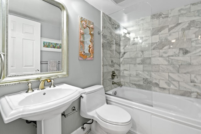 bathroom featuring toilet and tiled shower / bath combo