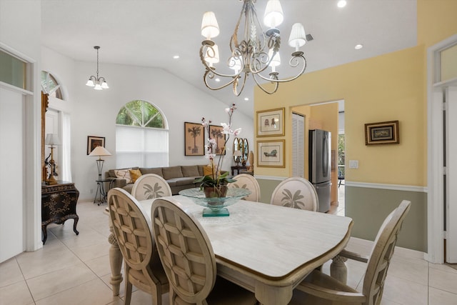 dining space with light tile patterned floors, vaulted ceiling, and an inviting chandelier